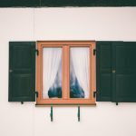 glass window with wooden frame white curtain inside